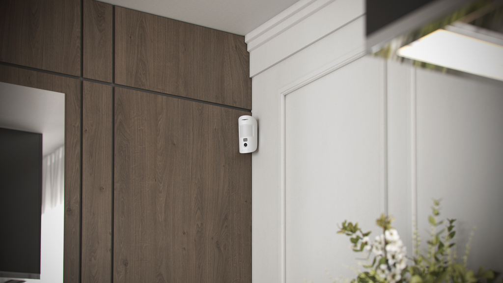 Ajax MotionCam motion detector with photo verification mounted on a home wall in white